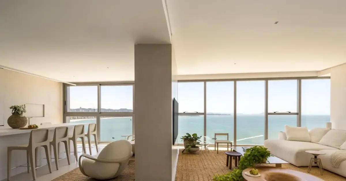 Apartamento no litoral reorganiza planta para ampliar convivência e enquadrar o mar