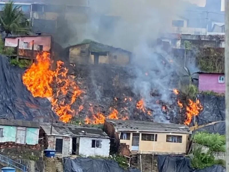 Bombeiros controlam fogo em entulhos sob lona no Recife