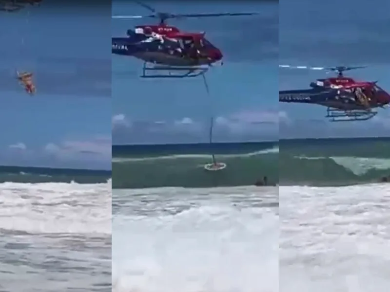 Operadores do GTA descem de helicóptero para retirar banhistas do mar em Pernambuco