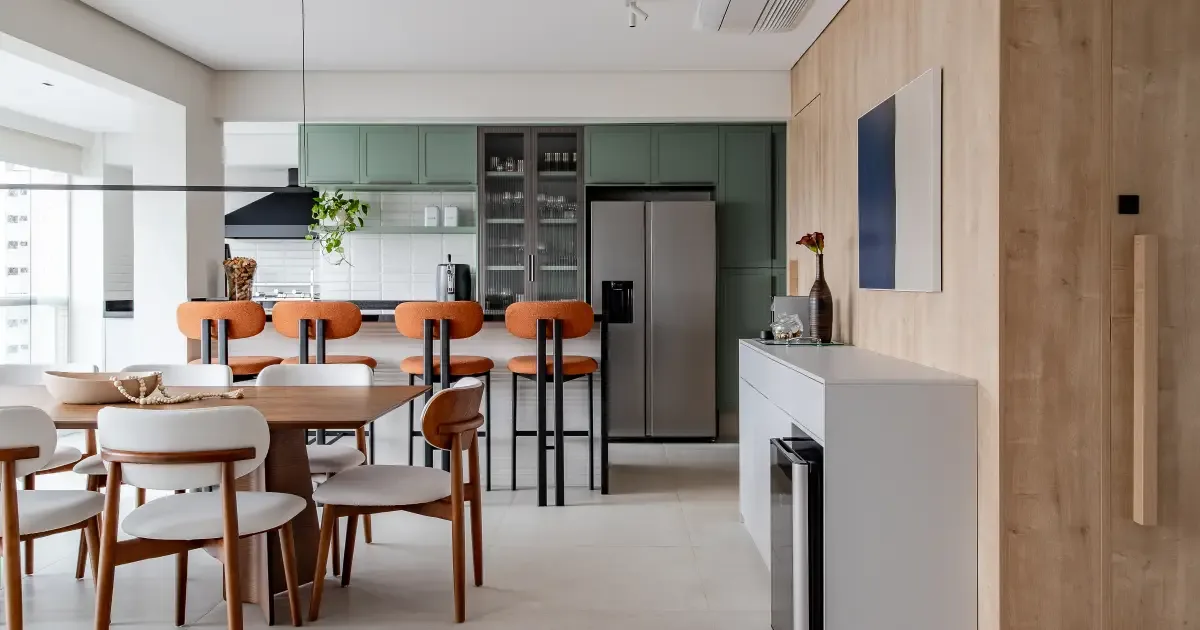 Apartamento em São Paulo integra sala, varanda e cozinha com marcenaria e cores suaves